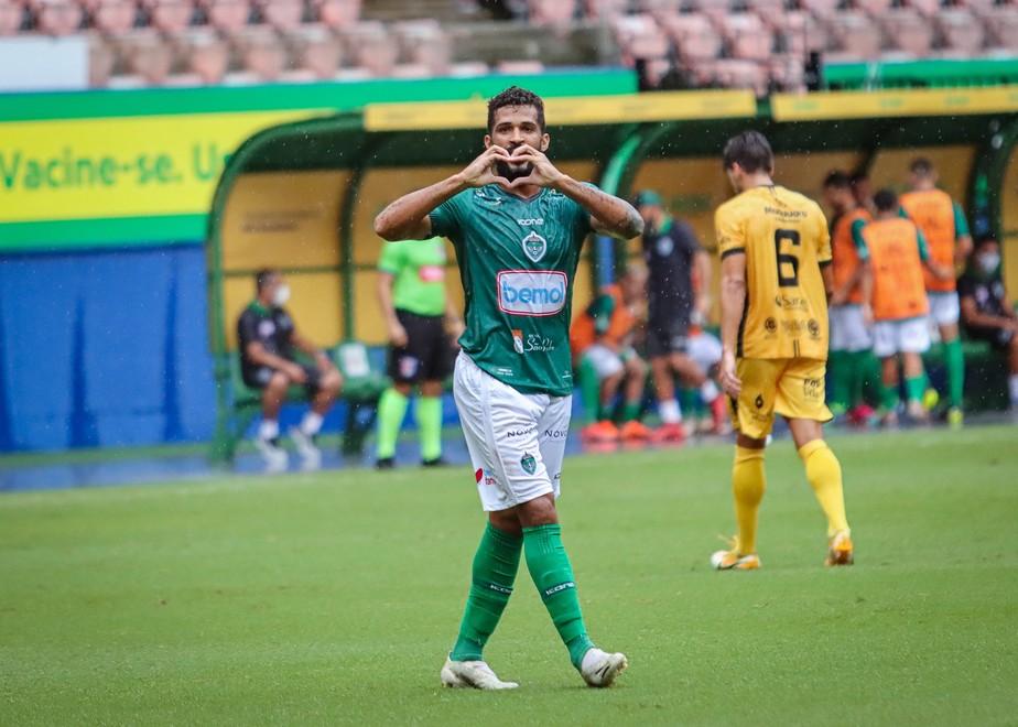 Alvinho fazendo coração com as mãos dentro de campo