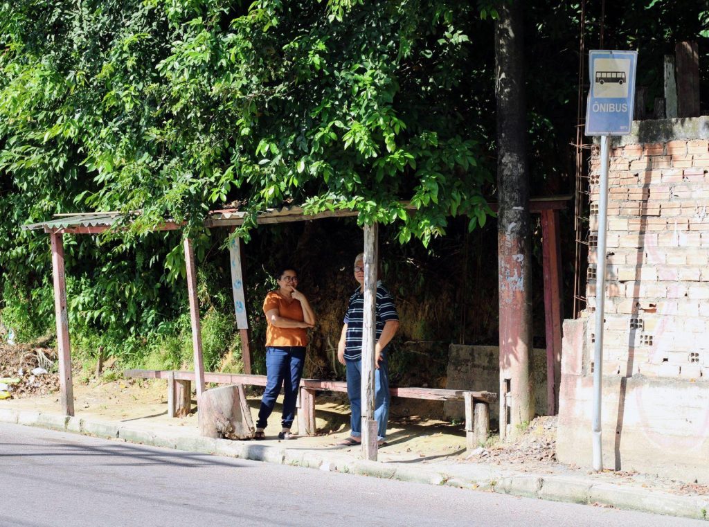 Para escapar do sol e chuva, moradores do Monte das Oliveiras improvisam abrigo em ponto de ônibus