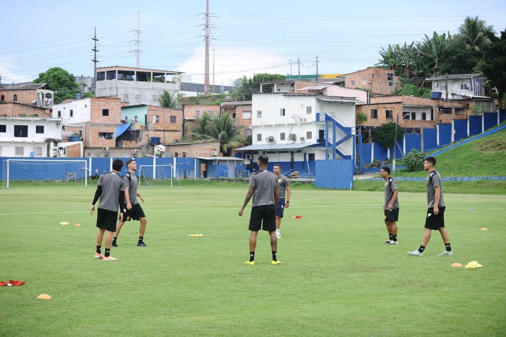 Jogadores do Nacional numa roda durante treinamento no CT Barbosa Filho. Eles usam um uniforme cinza