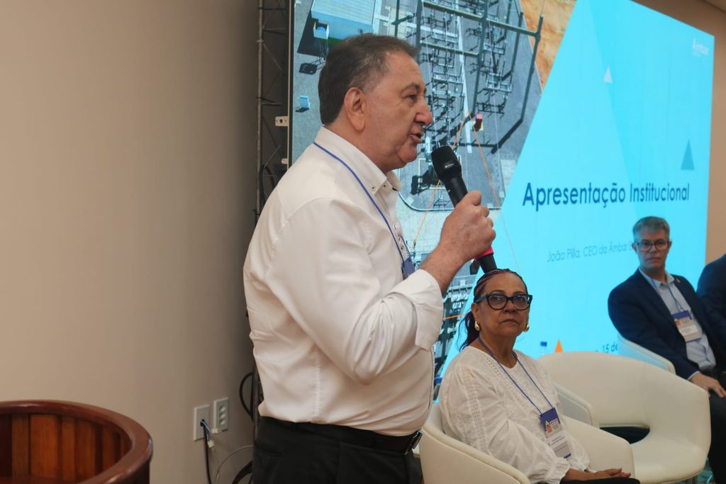 João Pilla, presidente da Âmbar Energia, falando no microfone durante encontro